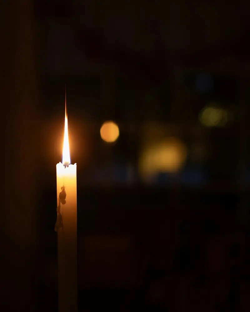 A single lit candle in a dark room